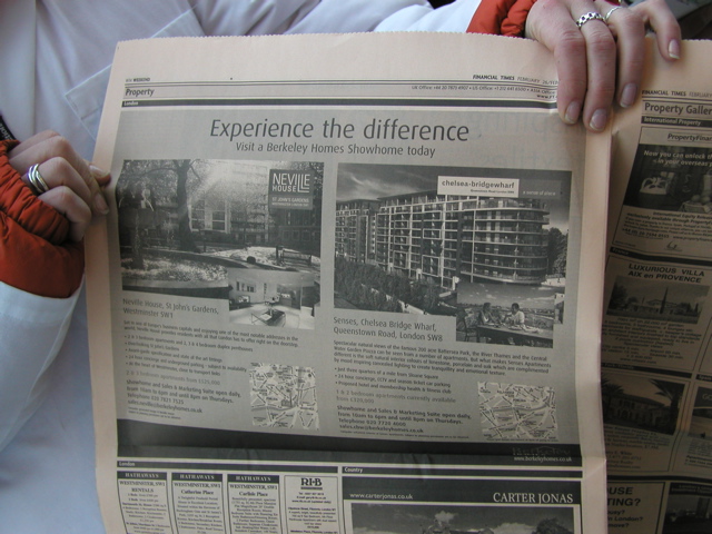 Hands hold a open newspaper with the words, `Explain the Difference' and showing two buildings in construction.
